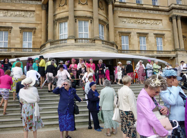 More ladies in their best outfits walking down the steps into the Palace gardens